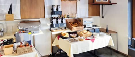 Een ontbijtbuffet met diverse gerechten en een koffiehoek.