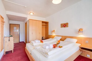 A hotel room with two beds, a wardrobe, a desk, and a wall-mounted light fixture. - Hotel Relais Alpin Twin Room & Balcony9 327, Les Mosses, Switzerland (Les Mosses)