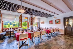 Un restaurante con varias mesas, sillas y vistas al exterior.