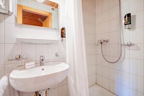 A bathroom with a white sink, a mirror, a shower, and a towel rack. - Hotel Relais Alpin Single Ski In-Out 5 223, Les Mosses, Switzerland (Les Mosses)
