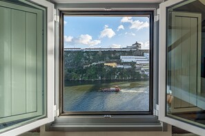 A window with a view of a river, a bridge, and buildings on a hillside. - GuestReady - Urban comfort with Douro River view (Porto)
