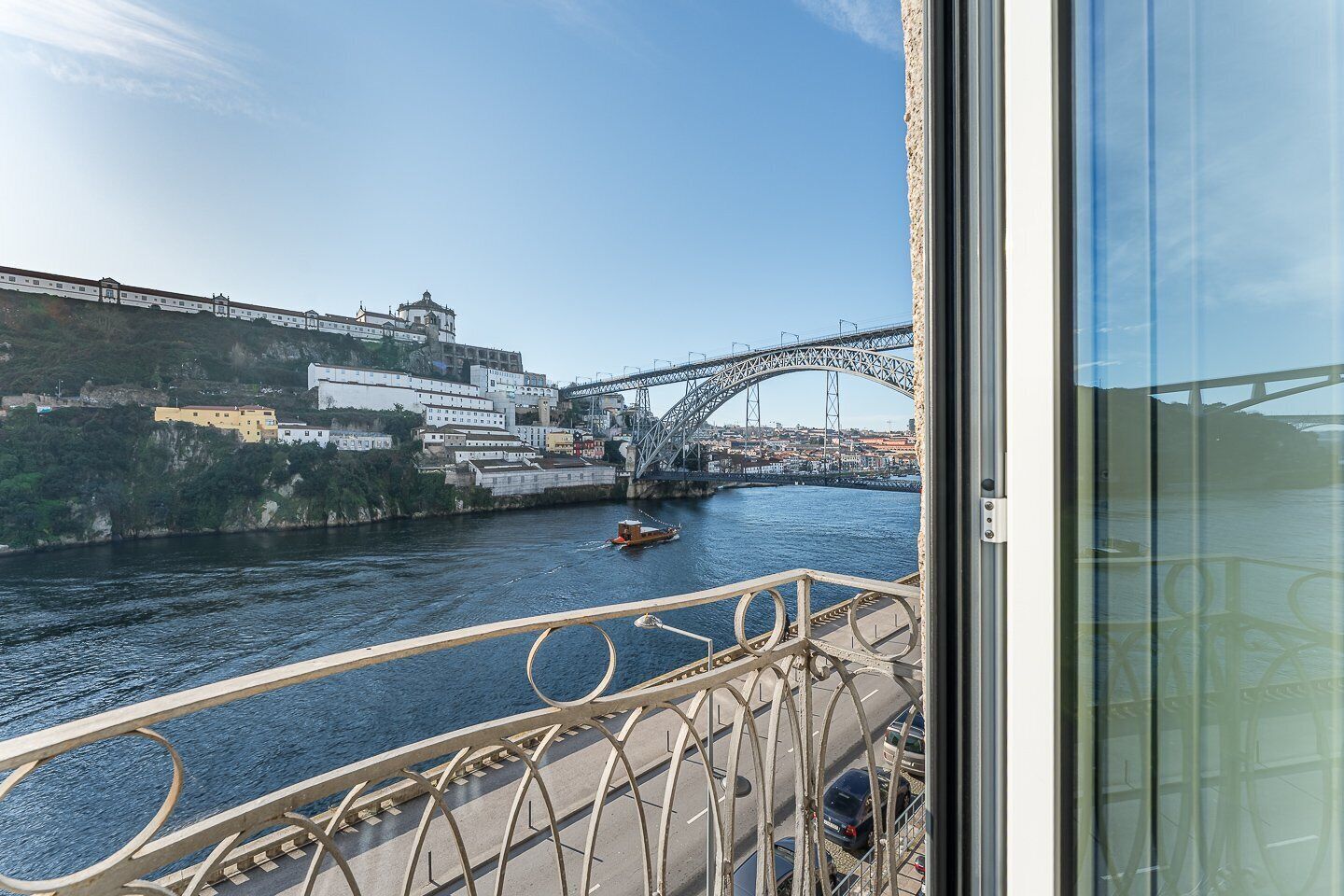Blick vom Balkon auf einen Fluss mit einer Brücke und Gebäuden im Hintergrund.