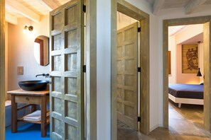 Une salle de bain avec un meuble-lavabo en bois, un lavabo noir et un miroir.