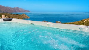 Een jacuzzi met een helder uitzicht op de oceaan en bergen op de achtergrond.