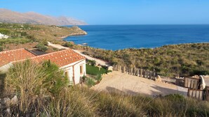 A coastal property with a red-tiled house, a dirt path, and a wooden fence. - Villa Zingaro with sea view and pool (Castellammare del Golfo)