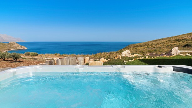 A hot tub with a clear view of the sea and hills in the background. - Villa Zingaro with sea view and pool (Castellammare del Golfo)