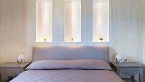 A bedroom with a bed, two bedside tables, and three wall-mounted lights. - Villa Zingaro with sea view and pool (Castellammare del Golfo)