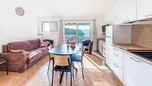 En kompakt bolig med spiseplads, tekøkken og sofa.