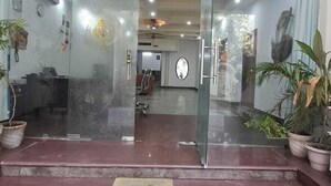 A reception area with a glass door, a "WELCOME" sign, and a reception desk. - Taj homes - A Unit of Sahni's Villa (Gurugram)