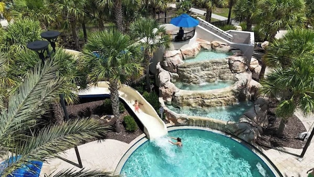 A pool area with a water slide, palm trees, and a hot tub. - Luxury Resort Pool House 6B5.5B perfect for family (Davenport)