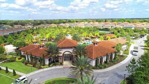 A residential area with a central building featuring a red-tiled roof, surrounded by lush greenery and a swimming pool. - Luxury Resort Pool House 6B5.5B perfect for family (Davenport)