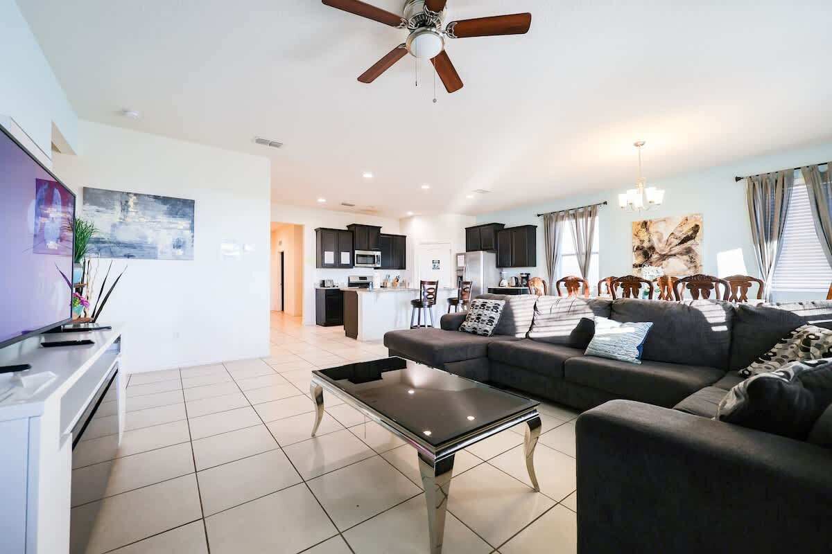 A modern living room with a sofa, coffee table, and a ceiling fan.