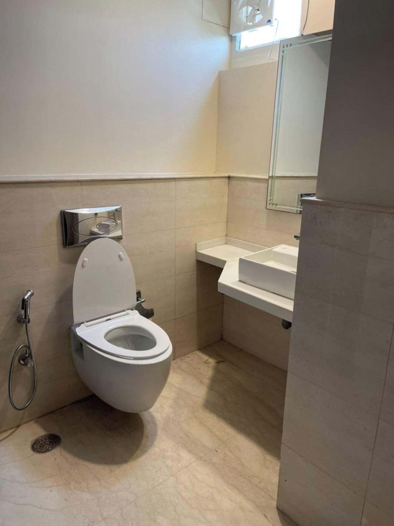 A modern bathroom with a toilet, a shower, and a sink.