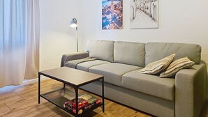Ein Wohnzimmer mit einer Couch, einem Couchtisch, einer Lampe und zwei Bildern an der Wand.