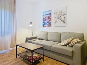 A living room with a sofa, a coffee table, a lamp, and two paintings on the wall. - Dalero 3 by Interhome (Trogir/Okrug Gornji)