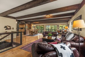 A spacious living room with leather sofas, a coffee table, and a dining area with wooden furniture. - 4BR Mountain Escape - Covered Hot Tub, Deck, near River (Leavenworth)