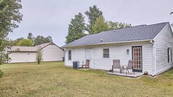 A single-story house with a front porch, a small attached garage, and a lawn.