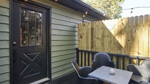 A wooden deck with a black door, a small table, and black chairs. - Newly remodeled 2BR in Chapel Hill (Chapel Hill)
