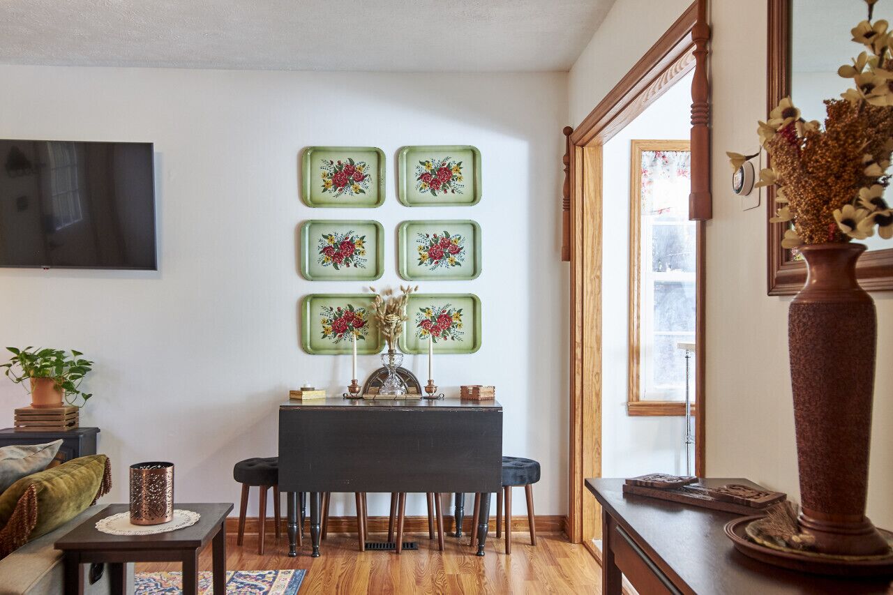 Un comedor con una mesa y sillas, un televisor de pantalla plana en la pared y una ventana con vistas.