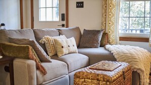 A cozy living room with a sofa, cushions, a woven basket, and a window with curtains. - Newly remodeled 2BR in Chapel Hill (Chapel Hill)