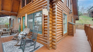 A log cabin with a porch, rocking chairs, and a sign that reads "The Porch Sit & Relax". - Resort-Style Smokies Cabin w/ Hot Tub + Game Room (Pigeon Forge)
