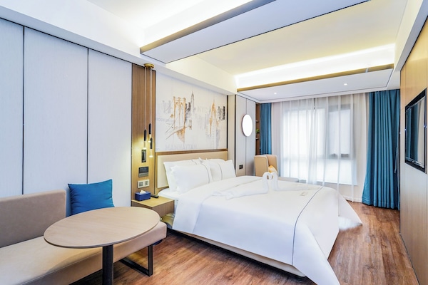 Cubrecamas, escritorio y espacio para trabajar con laptop