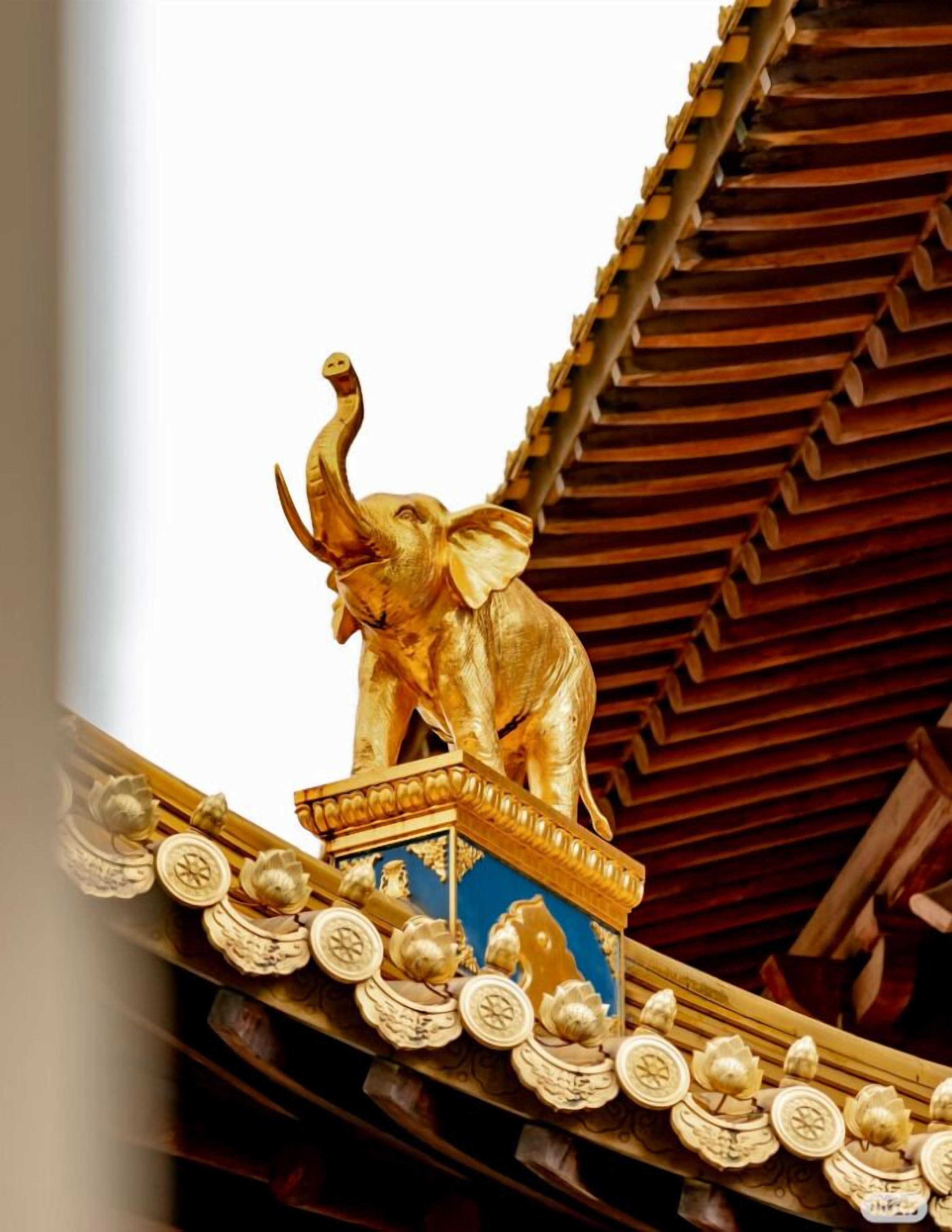 Een gouden olifantbeeld op een sierhekwerk met gedetailleerde versieringen.