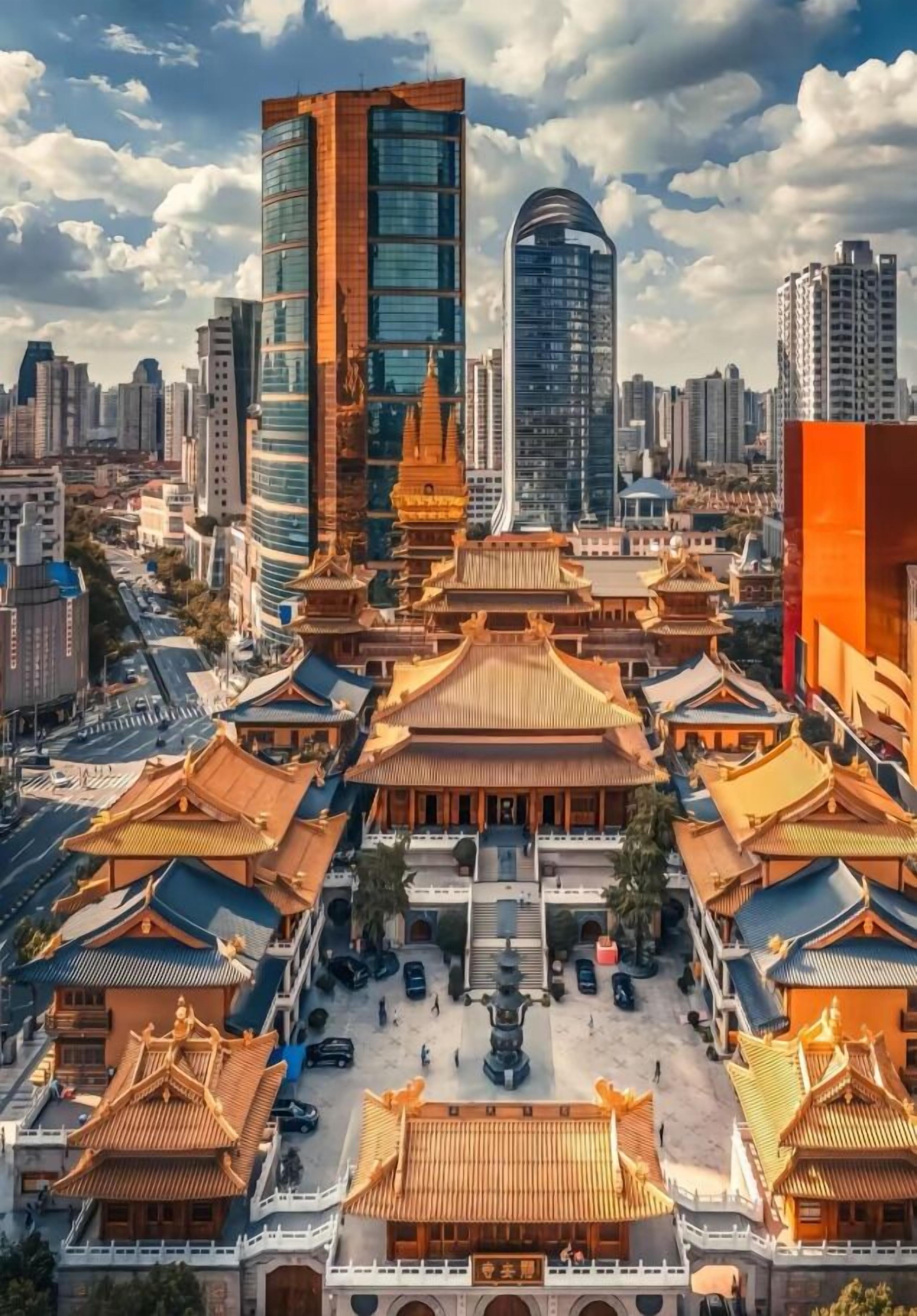 A traditional Chinese courtyard surrounded by modern high-rise buildings.