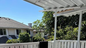 A covered patio area with a white fence, two folding chairs, and a small table. - Spacious 8-bedroom house in gorgeous Richmond with AC (Richmond)