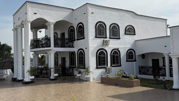 A white building with multiple arched windows and a covered courtyard. - Miky Hillside Lodge (Sunyani)