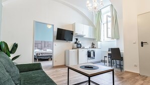 En kompakt bolig med tekøkken, spiseplads og soveværelse.