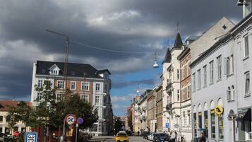 A street view with buildings, a yellow taxi, and a clear sky.