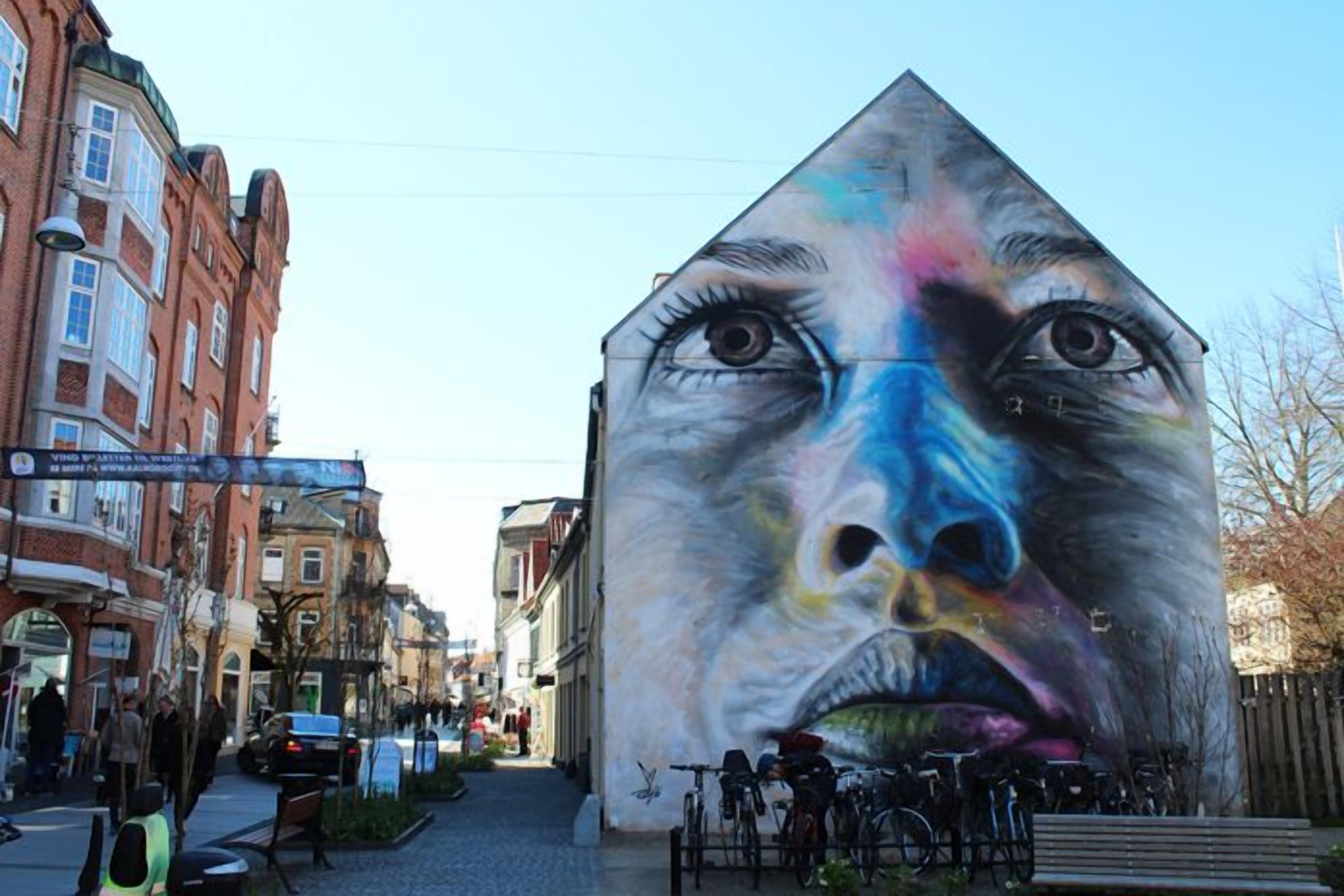 En gade med et stort muralmaleri på en bygning.