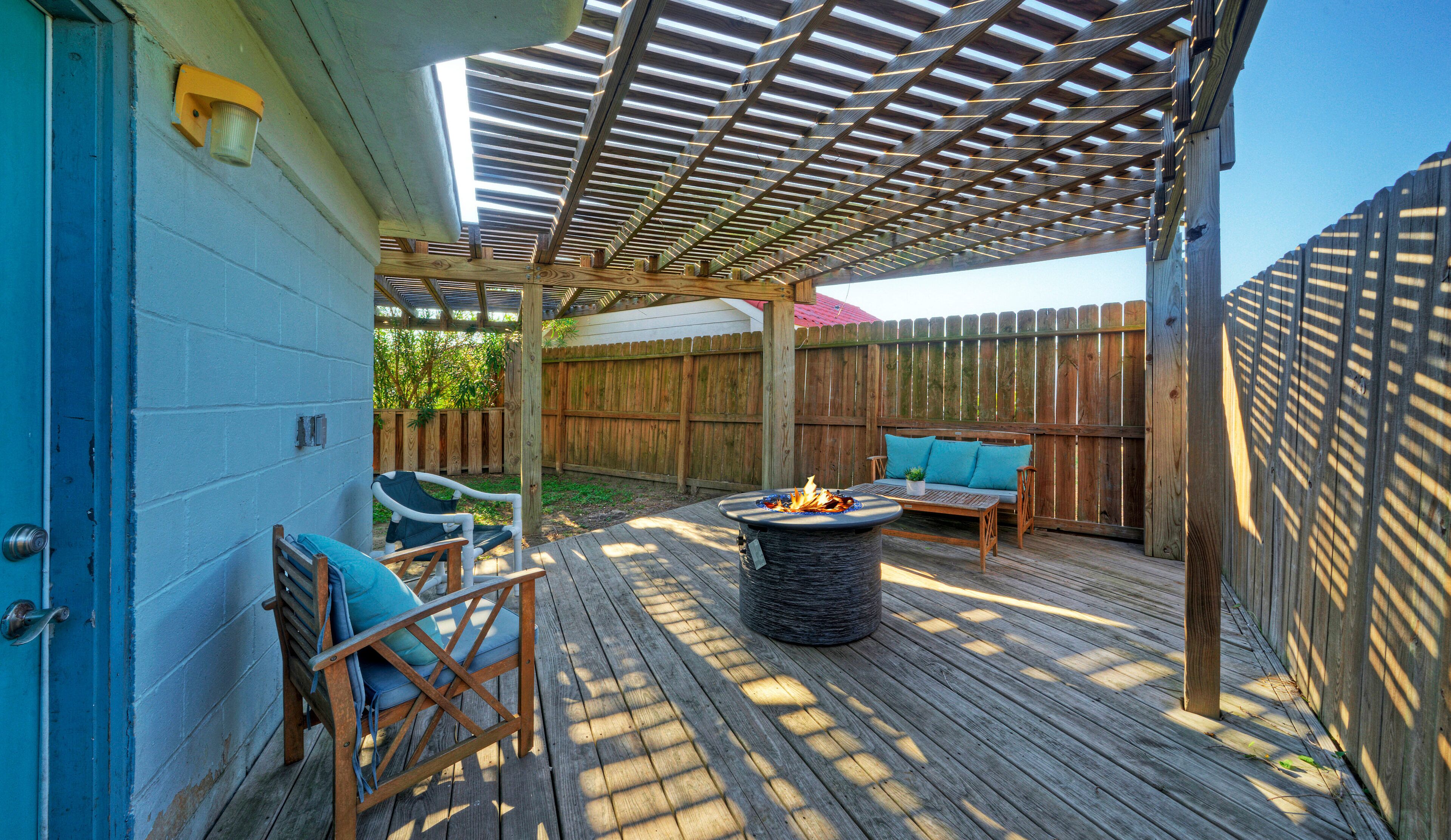 Un patio couvert avec un foyer, un espace salon et une terrasse en bois.