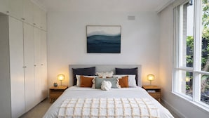 A bedroom with a bed, nightstands, a window, and a wardrobe. - Elwood Retreat - Sauna, 4 bedrooms, large garden, close to shops, cafe, train (Elwood)