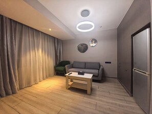 럭셔리 스튜디오 스위트 | 거실 공간 |   케이블 채널 시청이 가능한 120cm LCD TV, 스마트 스피커, 컴퓨터 모니터