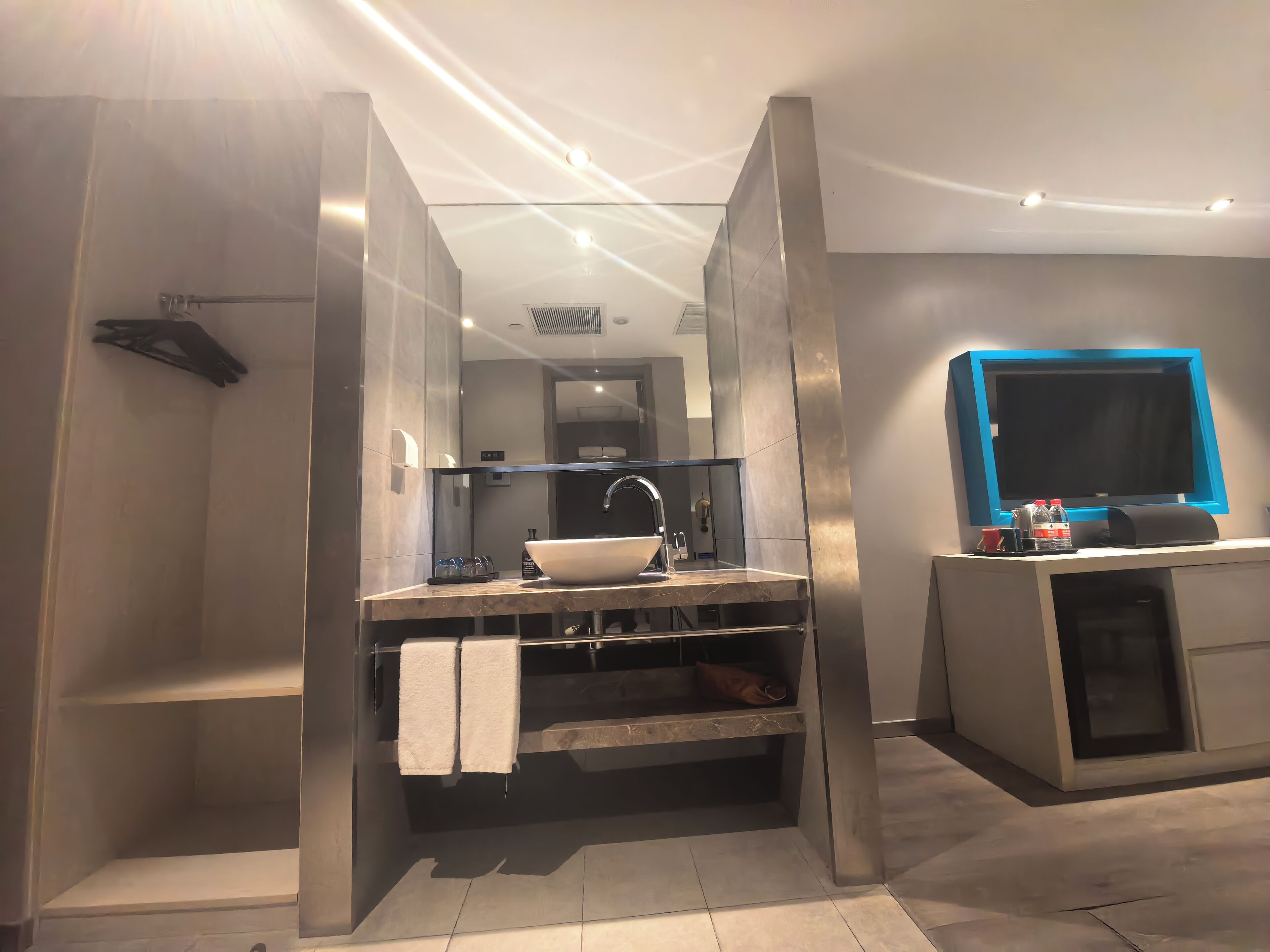 Un bagno moderno con lavabo incassato, uno specchio grande e cabina doccia.