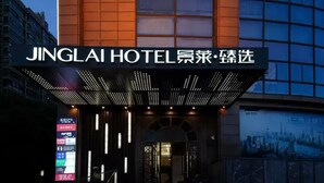 L’entrée de l’hôtel Jinglai, avec son enseigne lumineuse et son écran numérique.