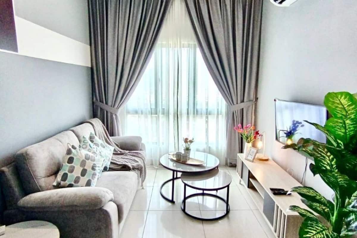 Een moderne woonkamer met een bank, een salontafel, een televisie en een plafondventilator.