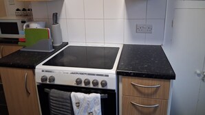 A kitchen with a stove, oven, microwave, and cabinets. - Southampton Serenity - 3 Bedroom Apartment (Southampton)