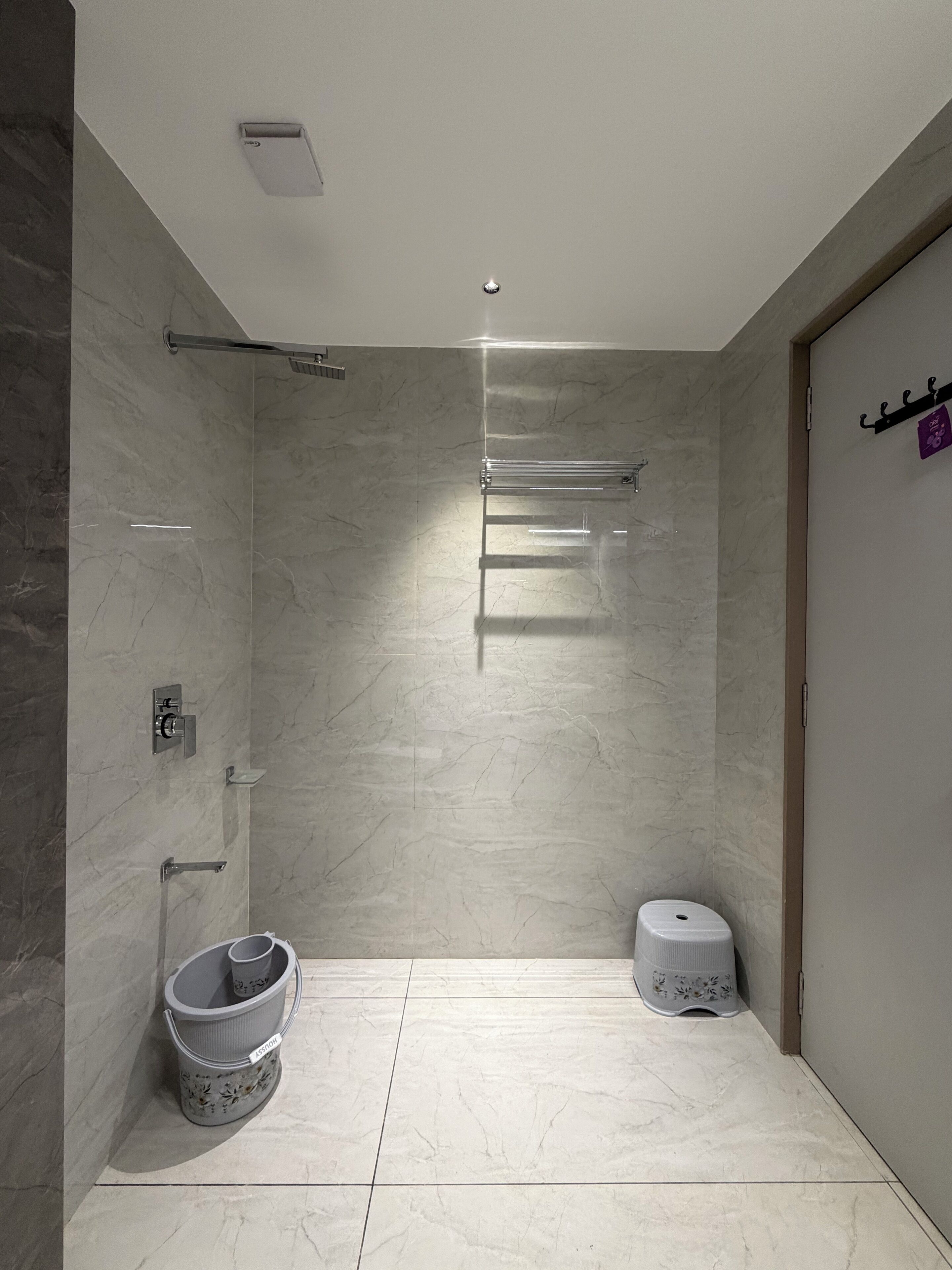 Une salle de bain moderne avec un sol en marbre, un espace douche et des toilettes.