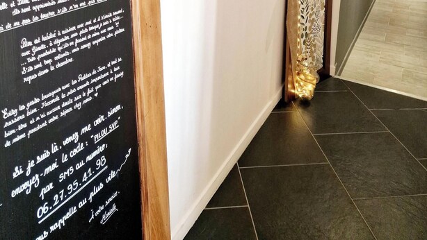 A hallway with a wooden signboard displaying text, a decorative wooden shelf with small items, and a modern kitchen area with a refrigerator. - La Maison des Oiseaux - A room in the heart of the Loire castles. (Crouzilles)
