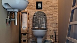 A compact bathroom with a toilet, sink, and a small wooden stool. - La Maison des Oiseaux - A room in the heart of the Loire castles. (Crouzilles)