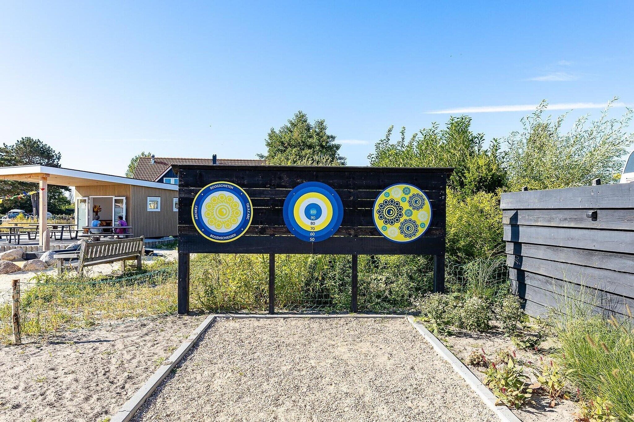 An outdoor archery range with targets and a covered seating area.