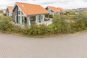 Ein modernes Wohngebiet mit Häusern, die Schrägdächer und große Fenster haben.