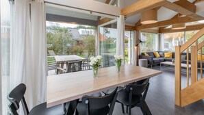 A modern interior with a dining area, a sofa, and a staircase. - modern comfort, close to the beach. (Renesse)