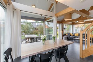 Ein modernes Interieur mit Essbereich, einer Couch und einer Treppe.