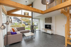 Ein modernes Wohnzimmer mit einer Couch, einem Couchtisch, einem Fernseher und einem Kamin.