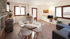 Un ambiente moderno con zona pranzo, cucina e angolo salotto.