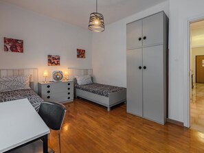 Ett modernt sovrum med en säng, sängbord, ett skrivbord och en garderob.